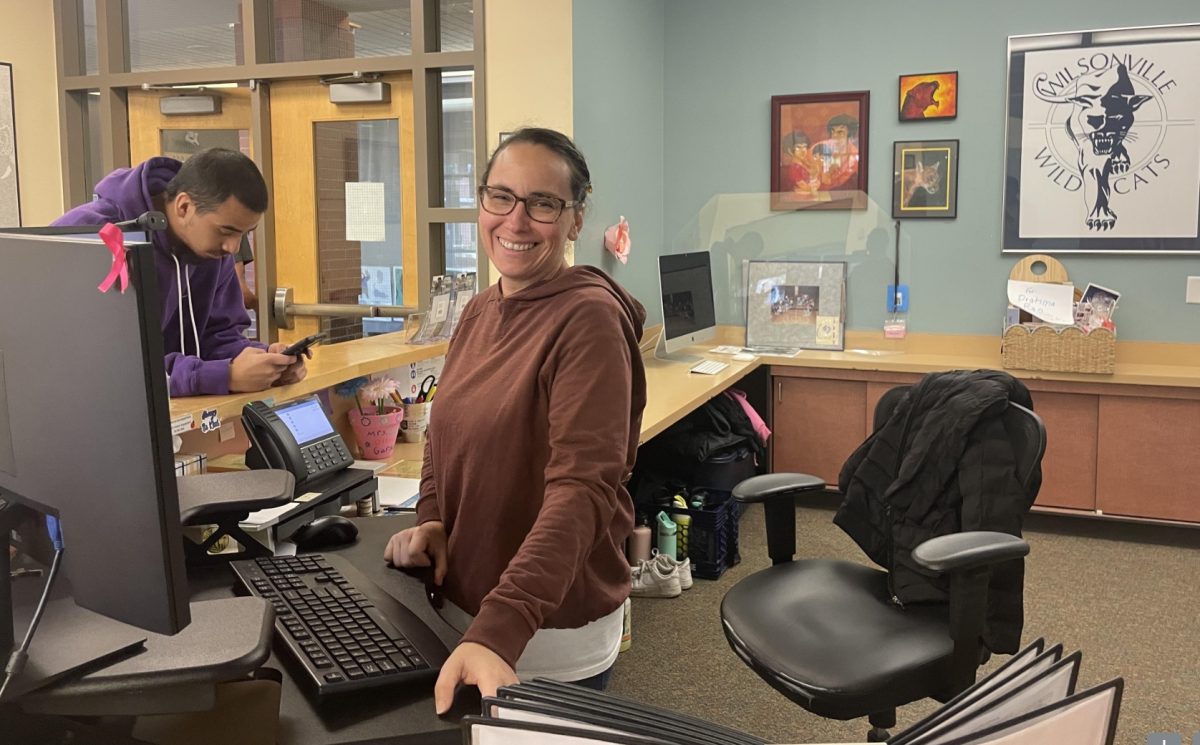 Our face of the school, Elda Bautista, in action at the front desk. She converses with hundreds of students and visitors each day. 